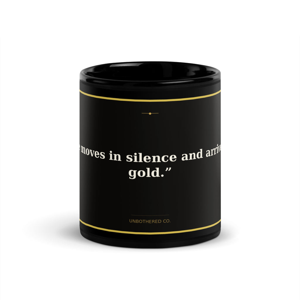 Black 11oz affirmation mug with gold text reading She Moves In Silence Arrives In Gold - Unbothered Co.
